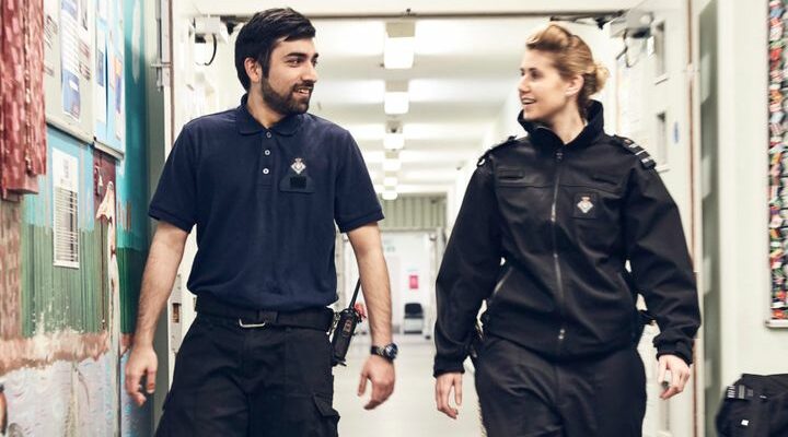 Two youth custody officers walking down a corridor